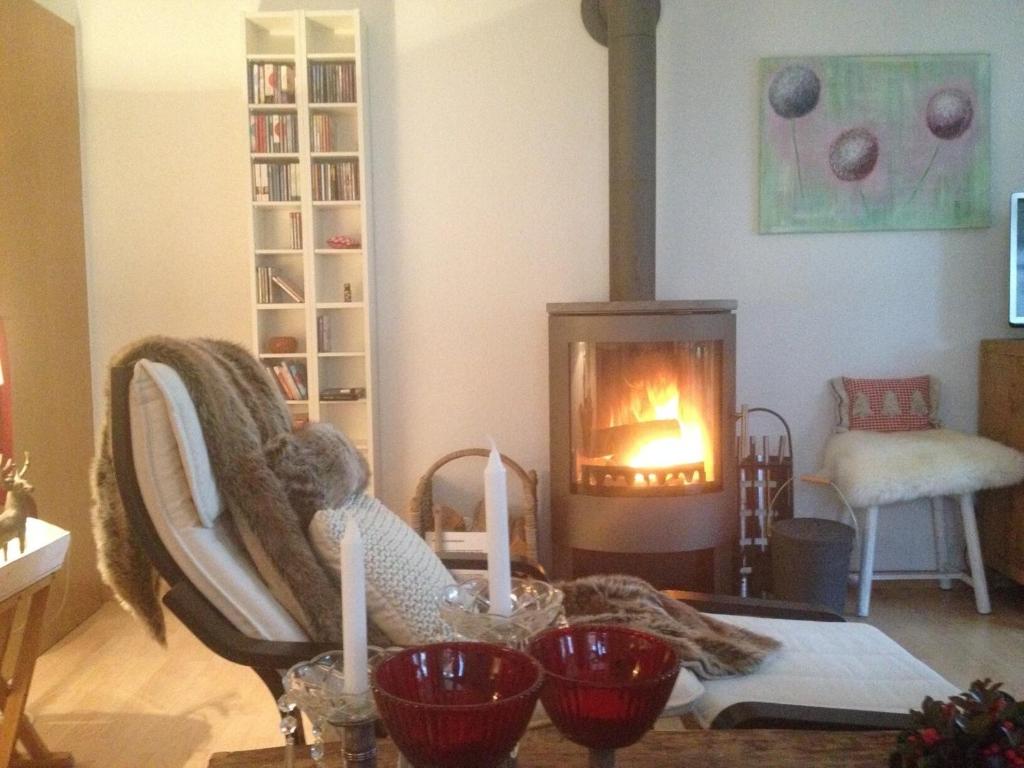 a living room with a fireplace and a table with candles at Chaletwohnung Alpenglück in Burgberg