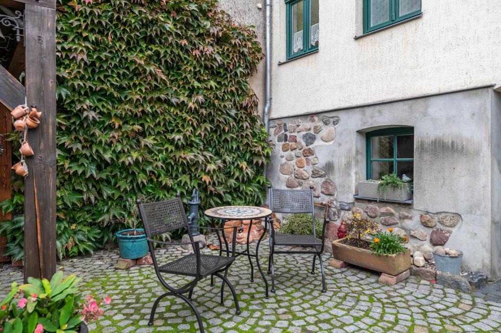 a patio with chairs and a table in front of a building at Fewo Altstadtkern Waren Müritz in Waren