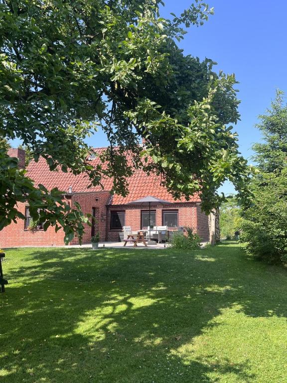 a brick house with a picnic table in a yard at Urlaub an der Elbmündung in Neuenkirchen