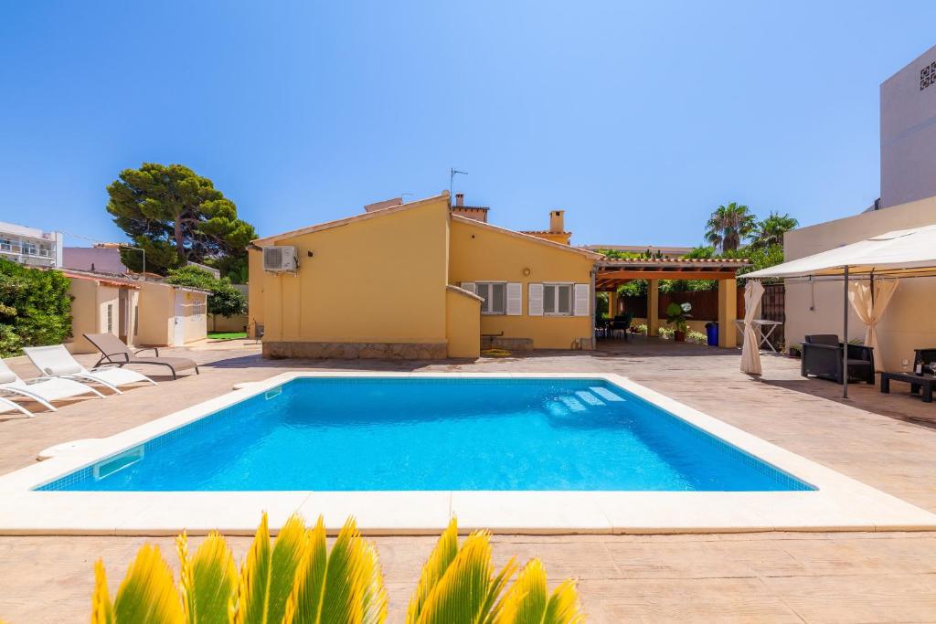 a swimming pool in a yard with a house at Bona Mar in Cala Ratjada