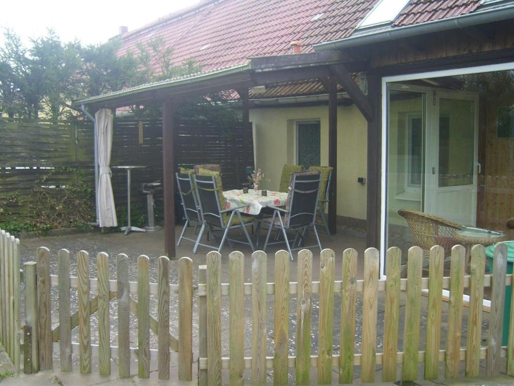 a patio with a table and chairs next to a fence at Ferienwohnung Kelpin in Möllenbeck