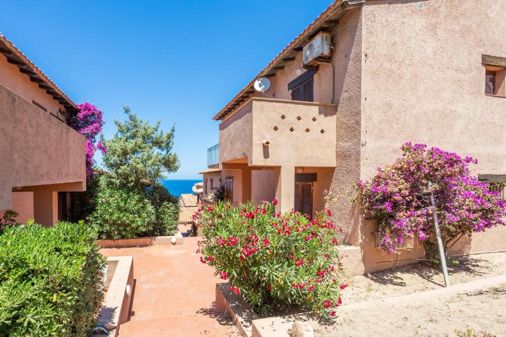 a house with flowers on the side of it at Casa Carlotta in Costa Paradiso in Costa Paradiso