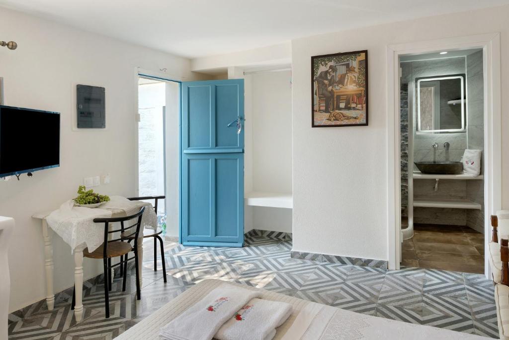 a living room with a blue door and a table at Politimi Studio N8 in Amorgos