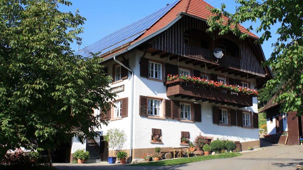 a building with a gambrel roof and flower boxes at Grundhof in Oberprechtal