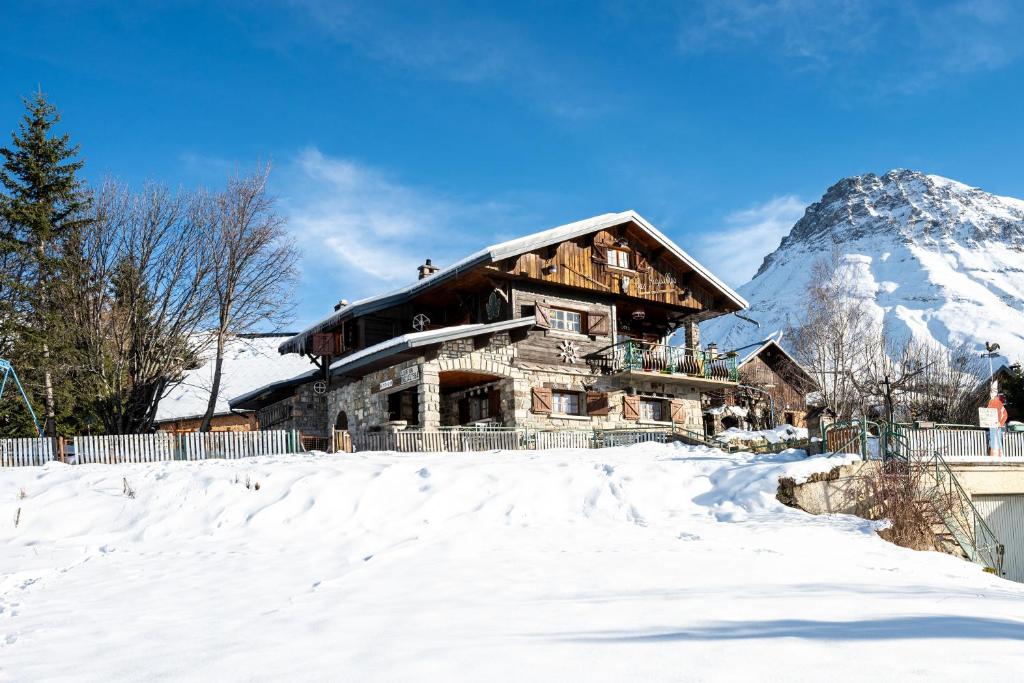 a log cabin in the snow with a mountain at Chalet les aiguilles in Albiez-Montrond