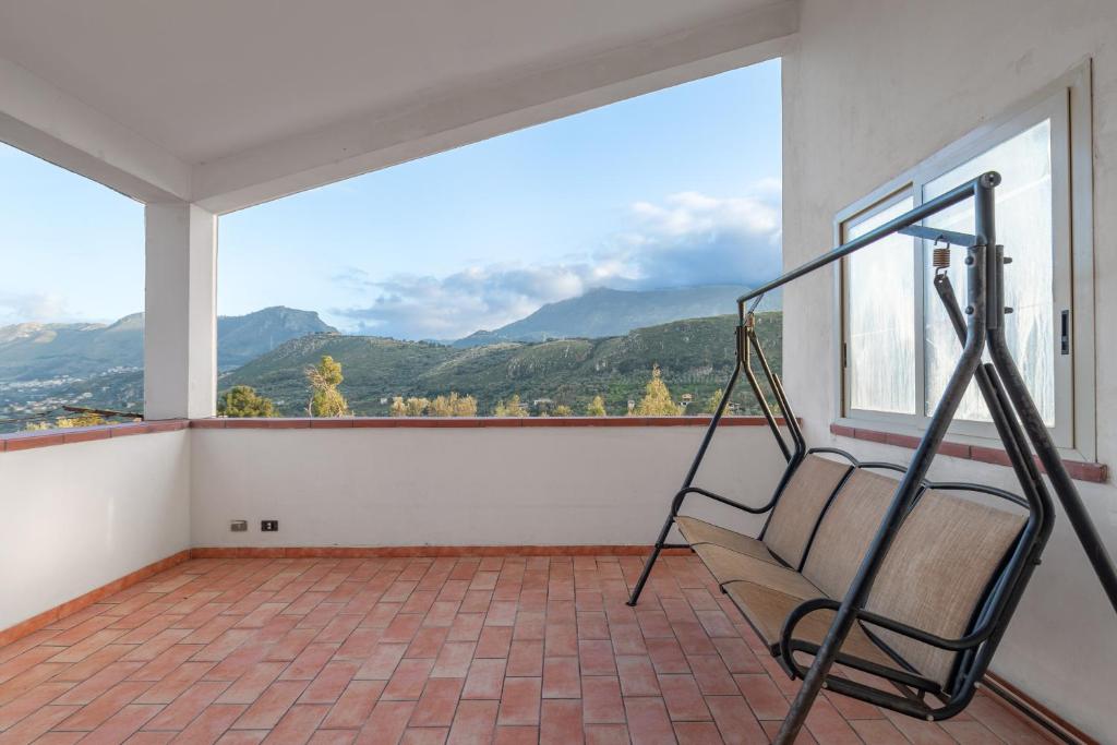 a balcony with a bench and a large window at Appartamento in Villa Marlory in Monreale