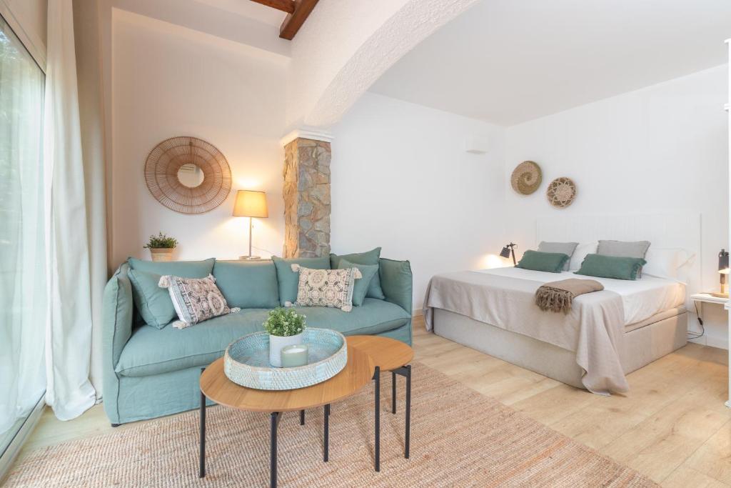 a living room with a blue couch and a bed at Bacom Apartment in Caldes de Malavella