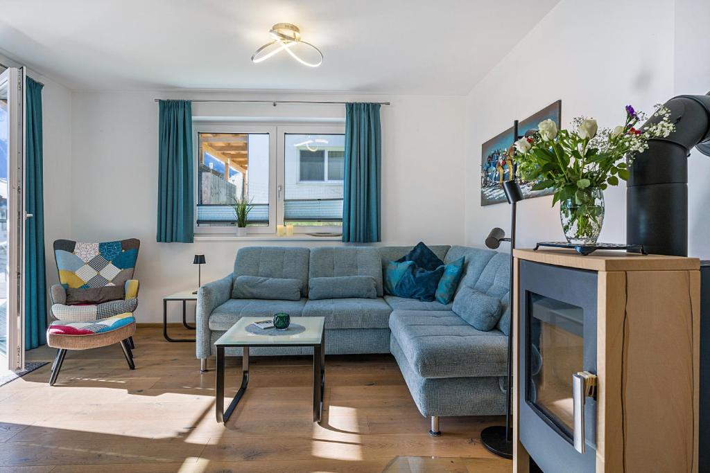 a living room with a blue couch and a table at Ferienwohnung Edelstein in Neukirchen am Großvenediger