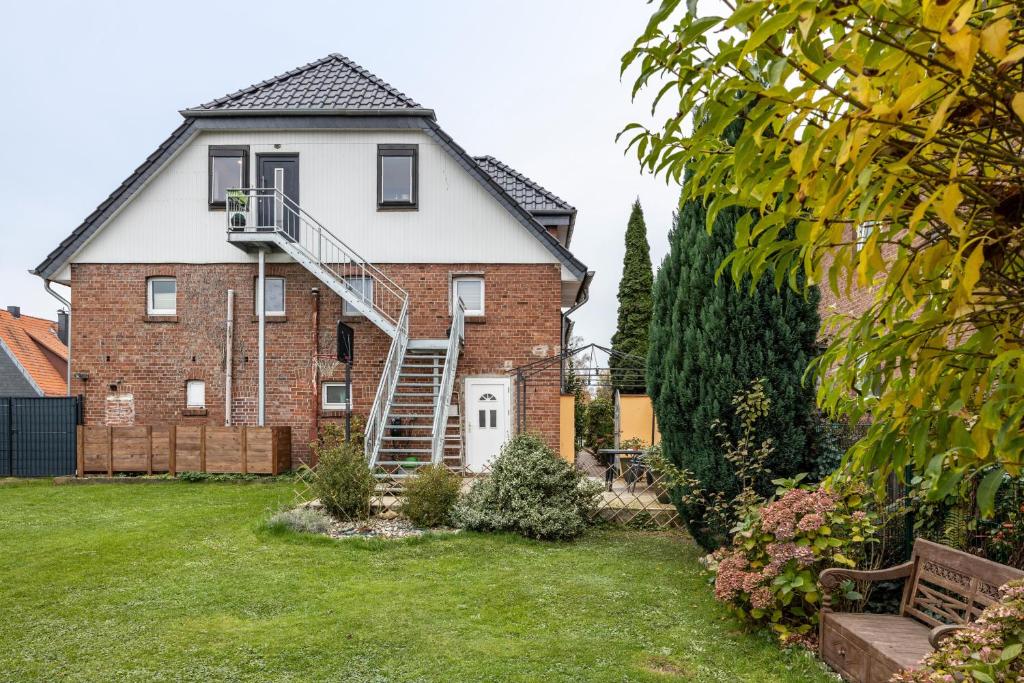 a large brick house with a staircase on it at Ferienwohnung Albatros Steinhude in Wunstorf