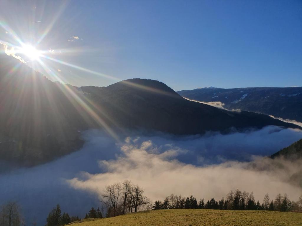 a view of the sun rising over a fog covered valley at Tratterhof Apt Astjoch in Vandoies