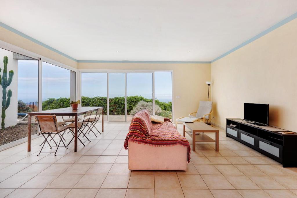 a living room with a table and a dining room at Casa Sirius in Tijarafe