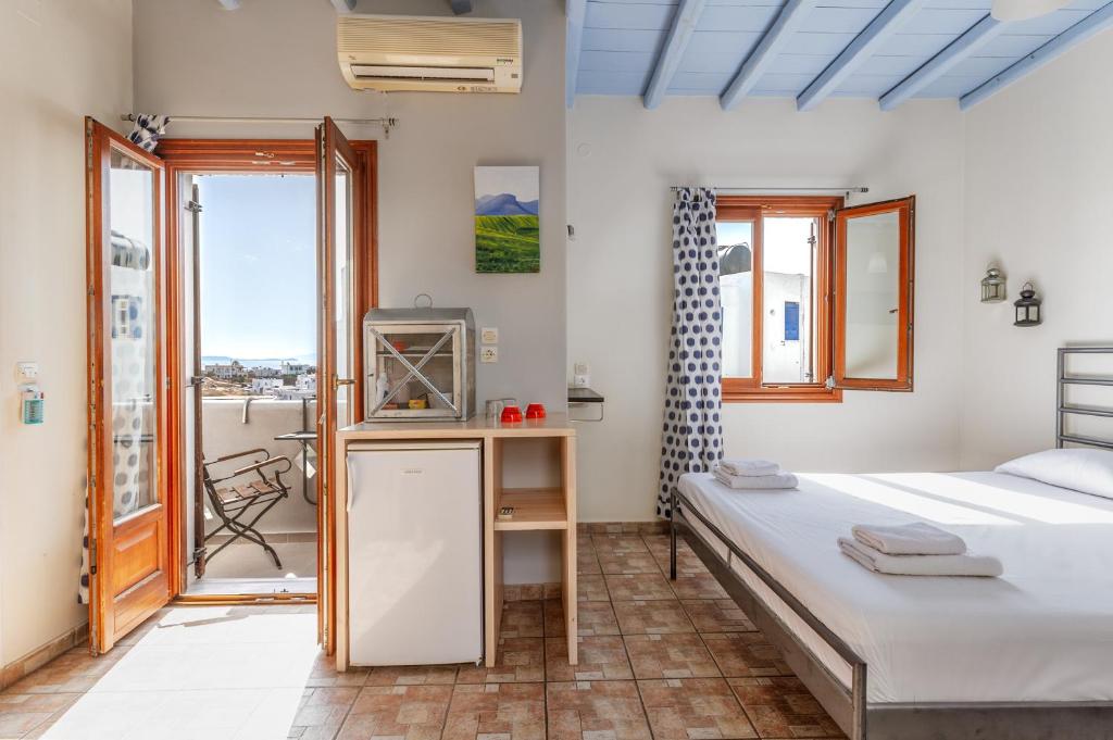 a bedroom with a bed and a tv and a window at En Tino 3 in Tinos