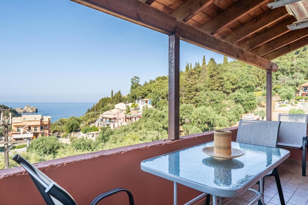 a table on a balcony with a view of the ocean at Arianna Grand apartment in Corfu