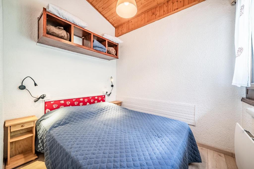 a bedroom with a blue bed in a room at Appt bien agencé, bien placé-Châtel in Châtel