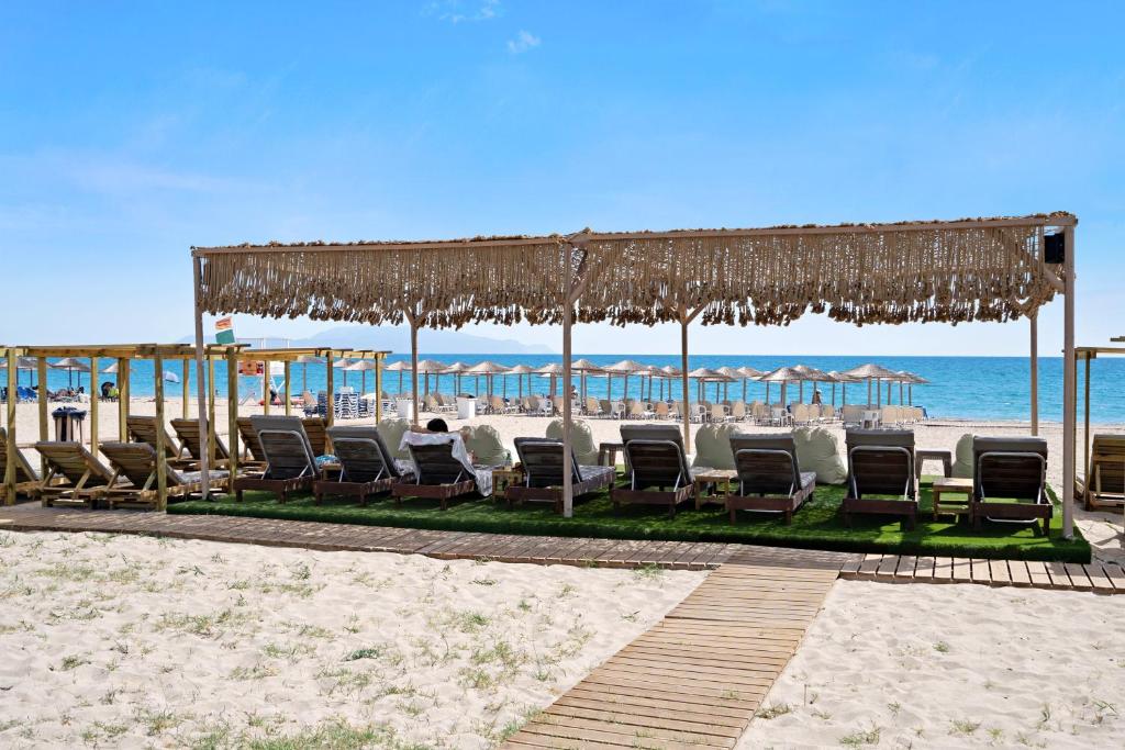 a group of chairs and umbrellas on the beach at Iguana studio 12 in Preveza