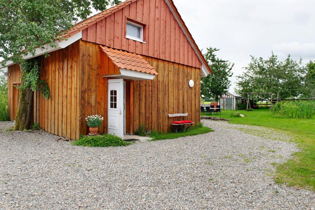 a barn with a white door and a red roof at Landhüsli Illmensee in Illmensee