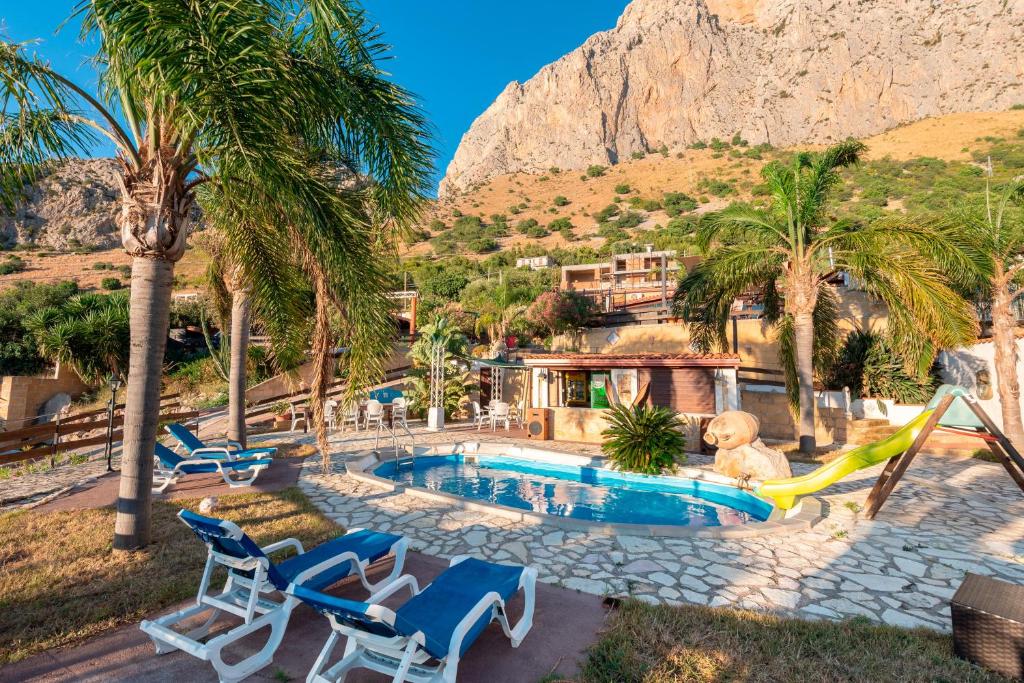 a swimming pool with chairs and a slide at Villa Ina in Cinisi