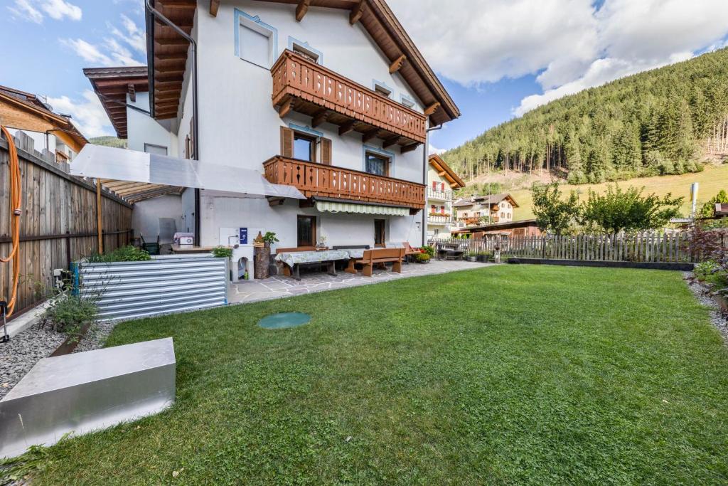 a house in the mountains with a yard at Ferienwohnung Ainhauser in Campolasta