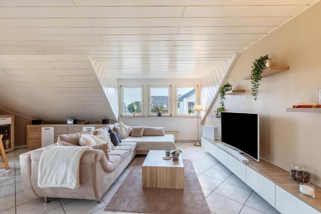 a living room with a couch and a tv at Ferienwohnung am Wald in Eppenrod