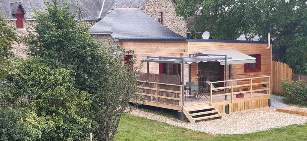 a wooden cabin with a staircase leading to a deck at Gîte Le Champ Du Bois in Missillac