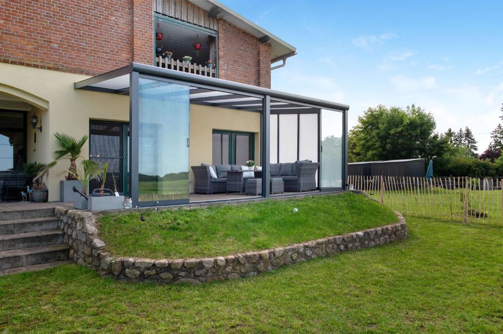 a glass extension of a house on a lawn at Hof Musial in Pokrent