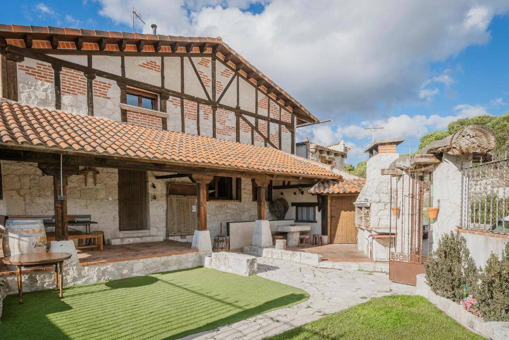 an exterior view of a house with a green lawn at El Pico Llanillo in San Miguel del Arroyo