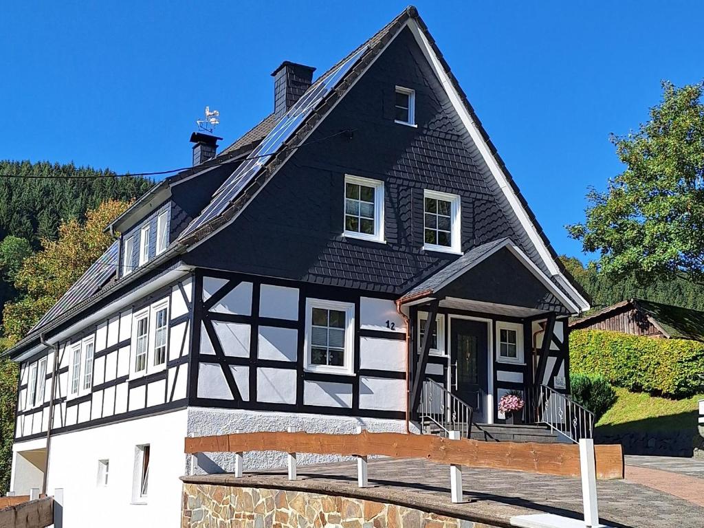 a black and white house with a black roof at Ferienwohnung Zur Basemicke in Schmallenberg