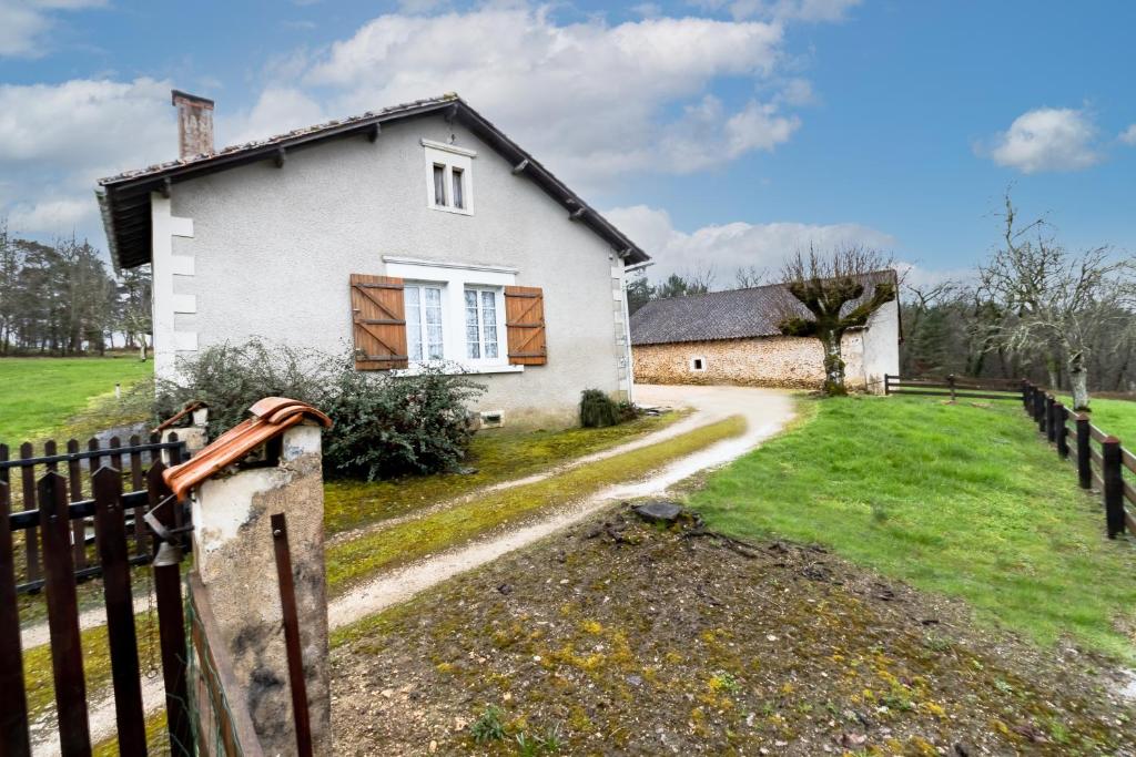 a white house with a fence and a road at Le haut Picot in Bussac