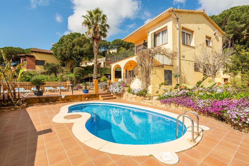 a villa with a swimming pool in front of a house at Disfruta De La Costa Brava in Lloret de Mar