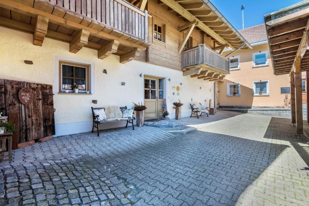 an outdoor patio with a bench and a building at Ferienwohnung Stub´n in Freyung