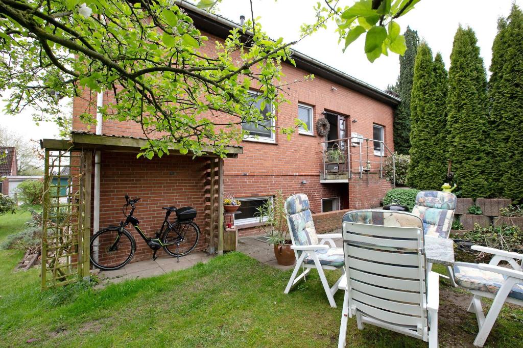 a bike parked next to a brick house with chairs at Ferienwohnung Bunsoh in Bunsoh