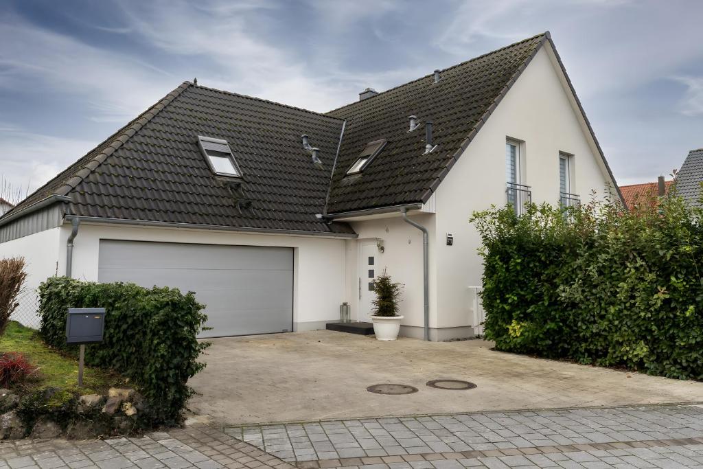 a white house with a garage at Appartement tout confort in Willstätt