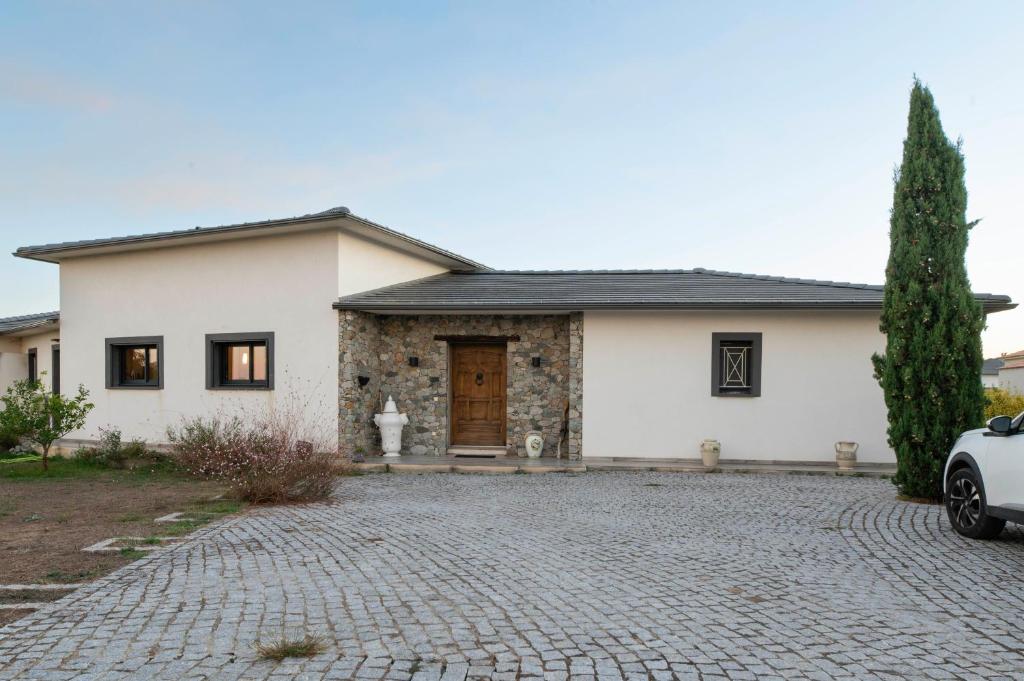 a white house with a brick driveway at Villa Helychrisa in Aléria