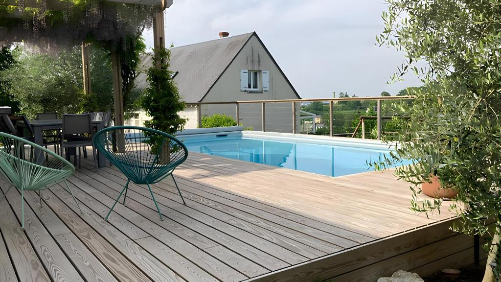 a deck with two chairs and a swimming pool at Chambre d'hôtes - La Gâtine in Rochecorbon