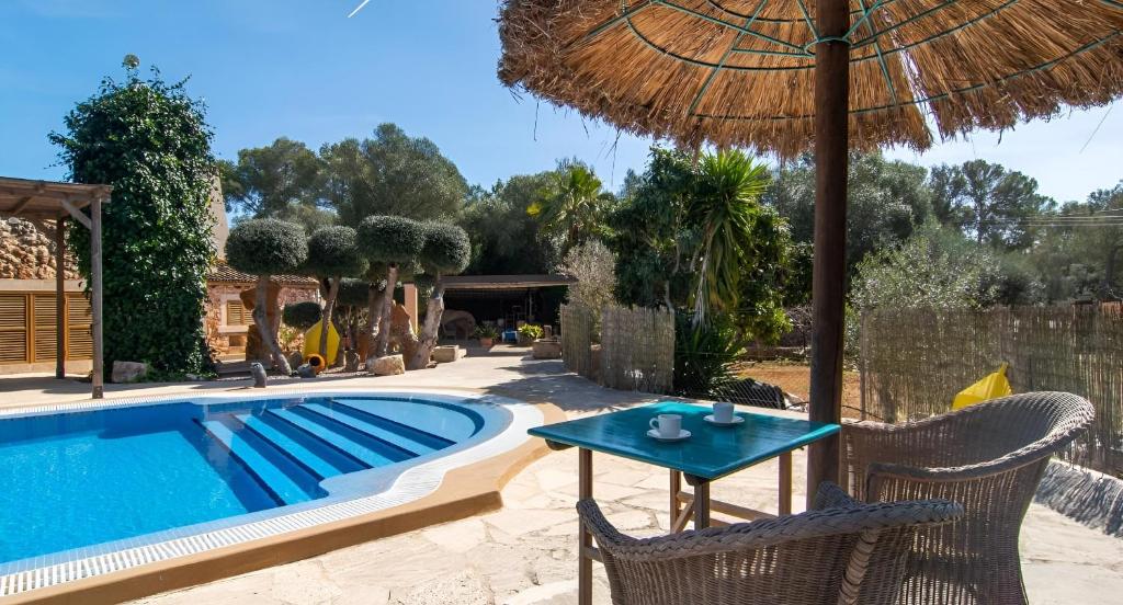 a patio with a table and chairs next to a swimming pool at Sa Costa in Campos