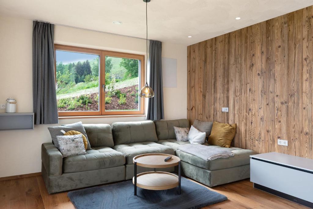 a living room with a couch and a window at Ratscheinerhof App Gipfelglück in Lazfons