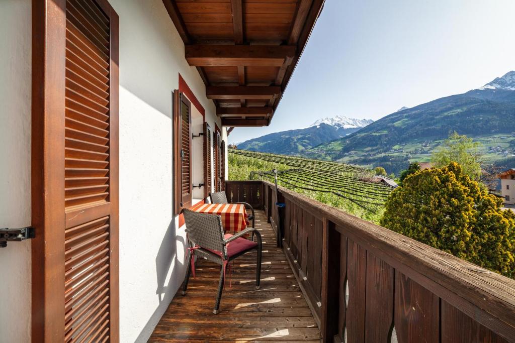 a balcony with a chair and a view of mountains at Gasserhof Ferienwohnung Gravenstein in Caines