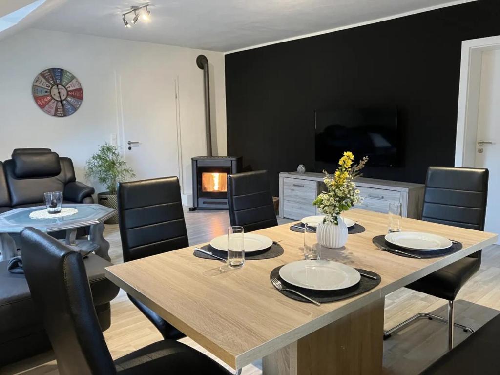 a dining room and living room with a table and chairs at Ferienwohnung Sauerlandherz in Lennestadt