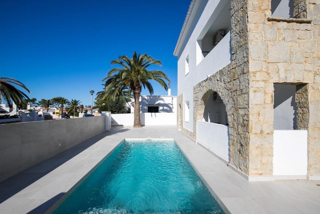 a swimming pool next to a building with a villa at Apartamento Marei 3 in Cala Blanca