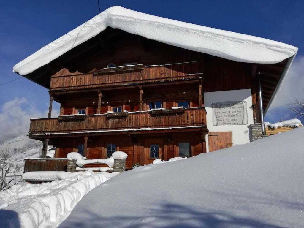 a large wooden building with snow on the roof at Ferienhaus Obersäuling in Stummerberg