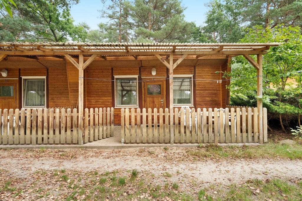 a wooden cabin with a fence in front of it at Bungalow 32 - Kimbucht in Reichendorf
