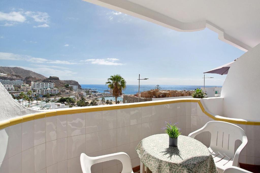 a balcony with a table and chairs and the ocean at Casa Boti in Puerto Rico de Gran Canaria