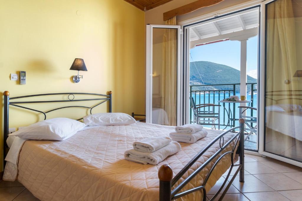 a bedroom with a bed with towels and a balcony at Apostolos Apartment 6 in Póndi