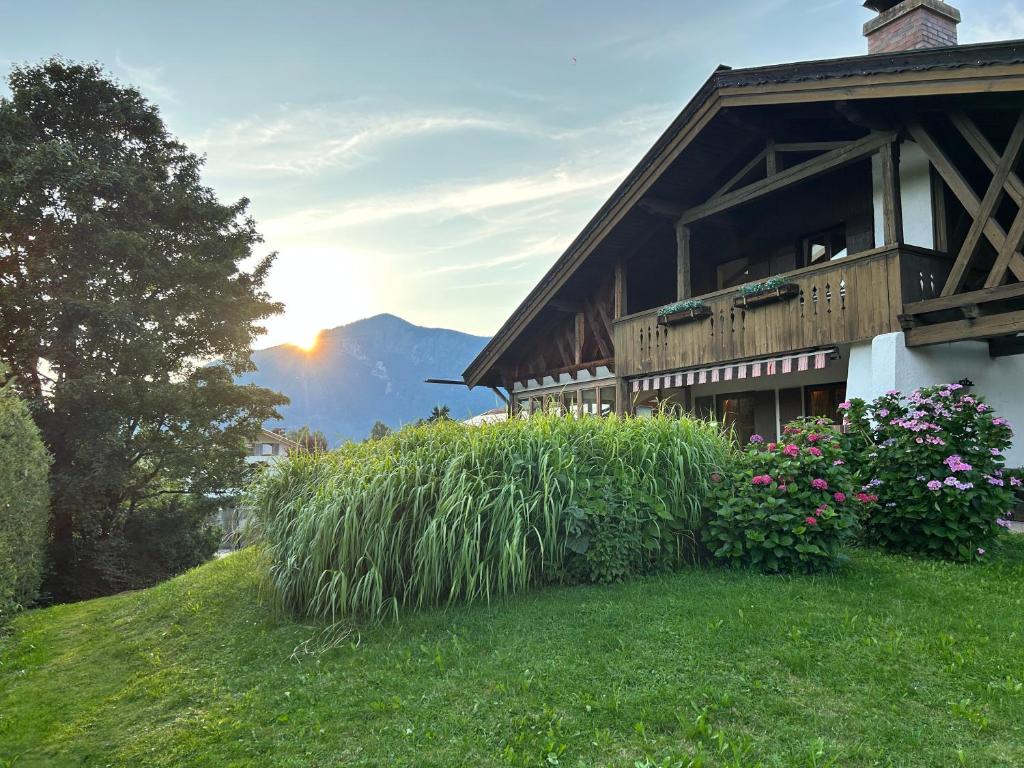 a house on a hill with grass and flowers at Großes Ferienhaus mit Bergblick in Unterwössen