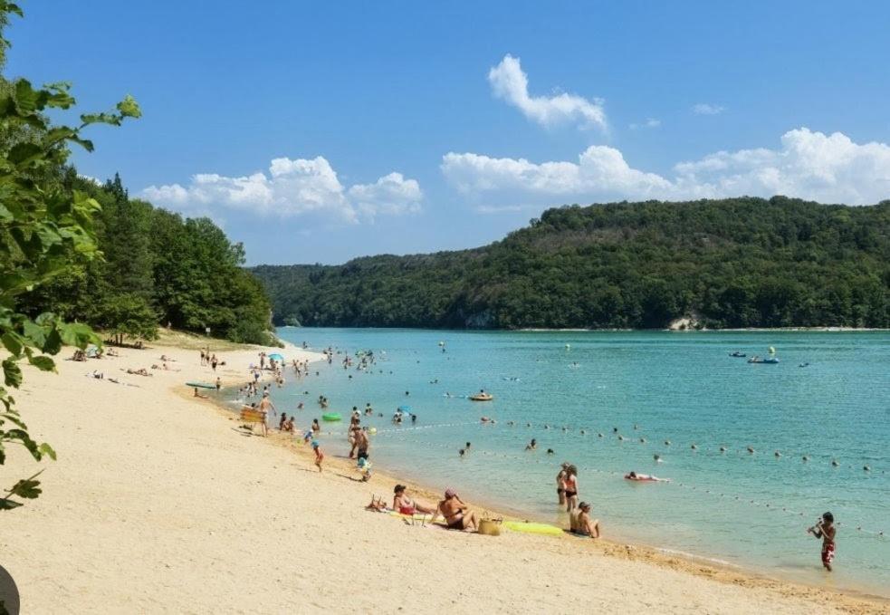a group of people in the water at a beach at Gîte Les Plaisirs du Lac avec spa & sauna in Charchilla