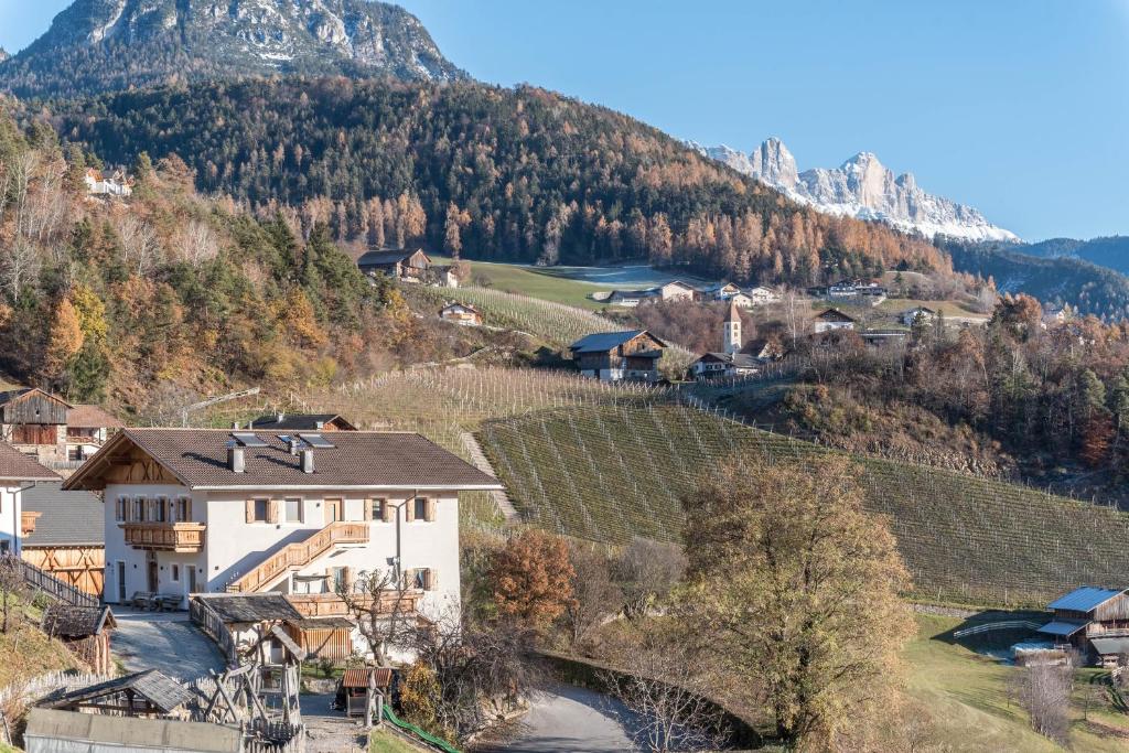 a house in a village with a mountain in the background at Guntschöllerhof Hochwart in Völs am Schlern