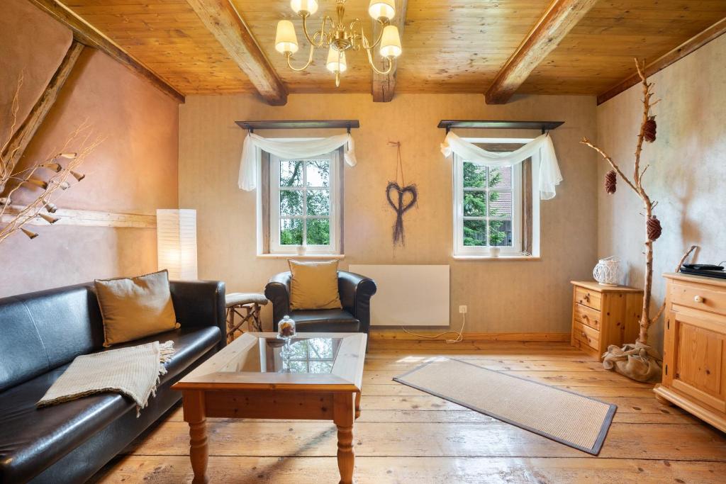 a living room with a leather couch and a coffee table at Ferienwohnung 'Zur Napoleonschanze' in Rathewalde