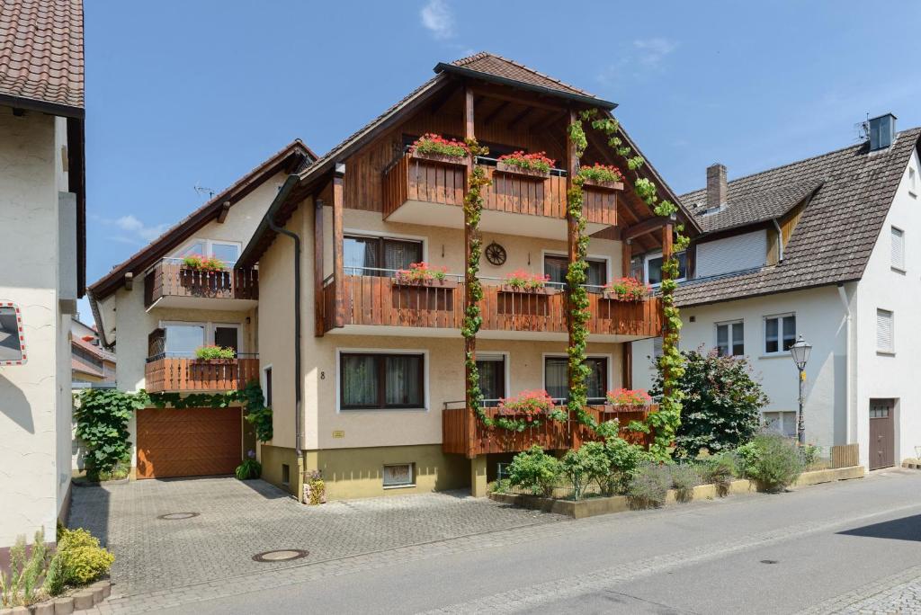 a building with flowers on the balconies on a street at Ferienwohnungen Kopp in Hagnau