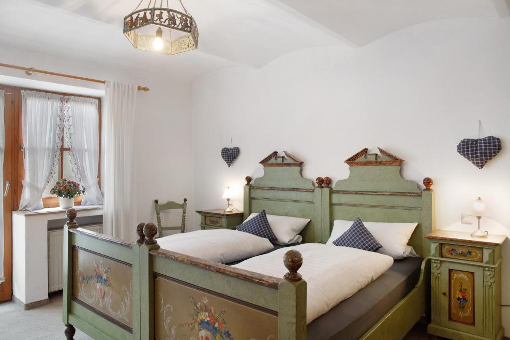 a bedroom with a large green bed with pillows at Zum Schnitzer Franzl in Garmisch-Partenkirchen