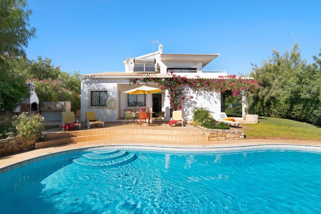 a house with a swimming pool in front of a house at Casa da Alfarrobeira in Loulé